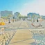 Spiaggia con ombrelloni chiusi e palme davanti a edifici