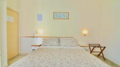 Letto matrimoniale con copriletto beige in stanza con pareti chiare