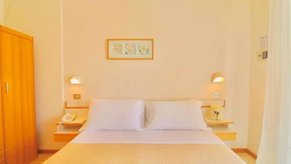 Camera da letto con letto matrimoniale, comodini e armadio in legno chiaro