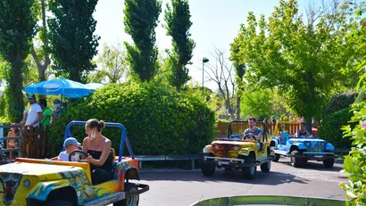 Persone che guidano macchinine colorate in un parco giochi all'aperto