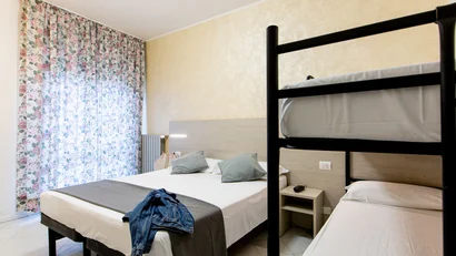 Camera con letto matrimoniale e letto a castello in ambiente luminoso