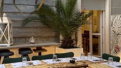 Tavoli di legno allestiti con menu e bicchieri in un dehor elegante