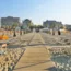 Strand mit geschlossenen Sonnenschirmen, Liegestühlen und Holzsteg zur Stadt